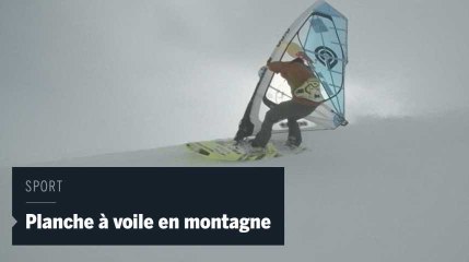 Un véliplanchiste dévale une montagne en planche à voile