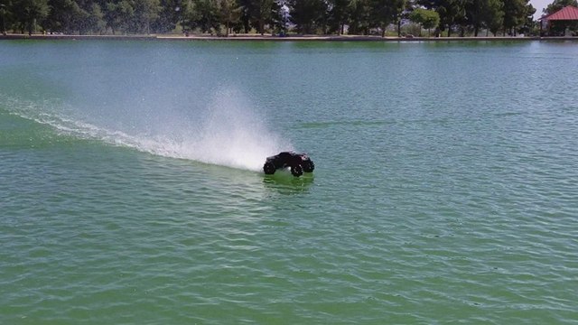 Il fait rouler sa voiture radiocommandée sur l'eau