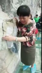 Grandma is scared of heights on a glass bridge