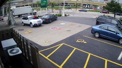 Une femme s'accroche au capot de sa voiture pour éviter un vol