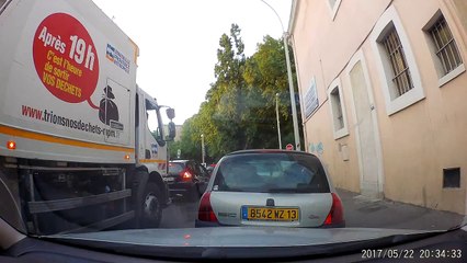 Un éboueur en Marseille en train de jeter des déchets par la fenêtre de son camion poubelle