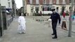Une nonne joue au foot dans la rue en faisant des jongles avec un policier