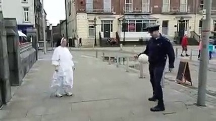 下载视频: Une nonne joue au foot dans la rue en faisant des jongles avec un policier