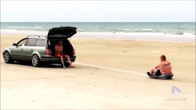 Ce gros se fait tirer par une voiture sur le sable