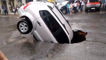Une voiture tombe dans un trou sur la route