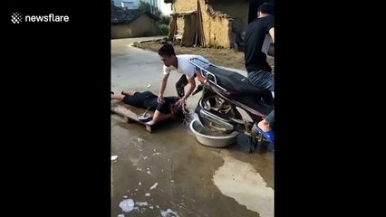 Man uses motorbike to wash and dry his hair