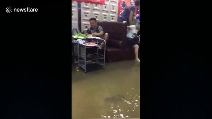 Restaurant customers continue meal despite flood
