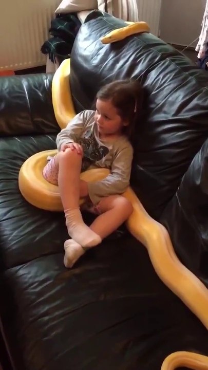 Une jeune fille regarde la TV avec son serpent...