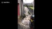 Floodwater gushes down steps after heavy rain in Scotland