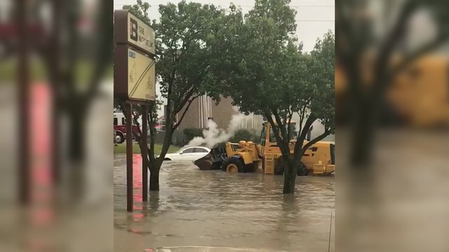 Il éteint le feu d'une voiture avec le godet de son chargeur sur pneus