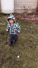 Un jeune enfant tente de faire un swing au golf