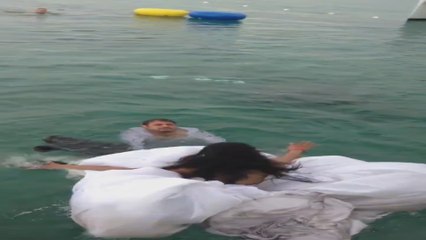 Noiva quase  morre afogada  por causa de seu próprio vestido, ao pular no mar durante festa de casamento.