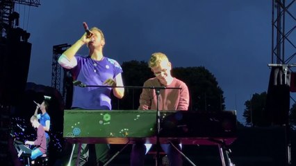 Un jeune homme monte sur scène avec Chris Martin