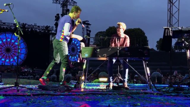 Un jeune homme monte sur scène avec Chris Martin
