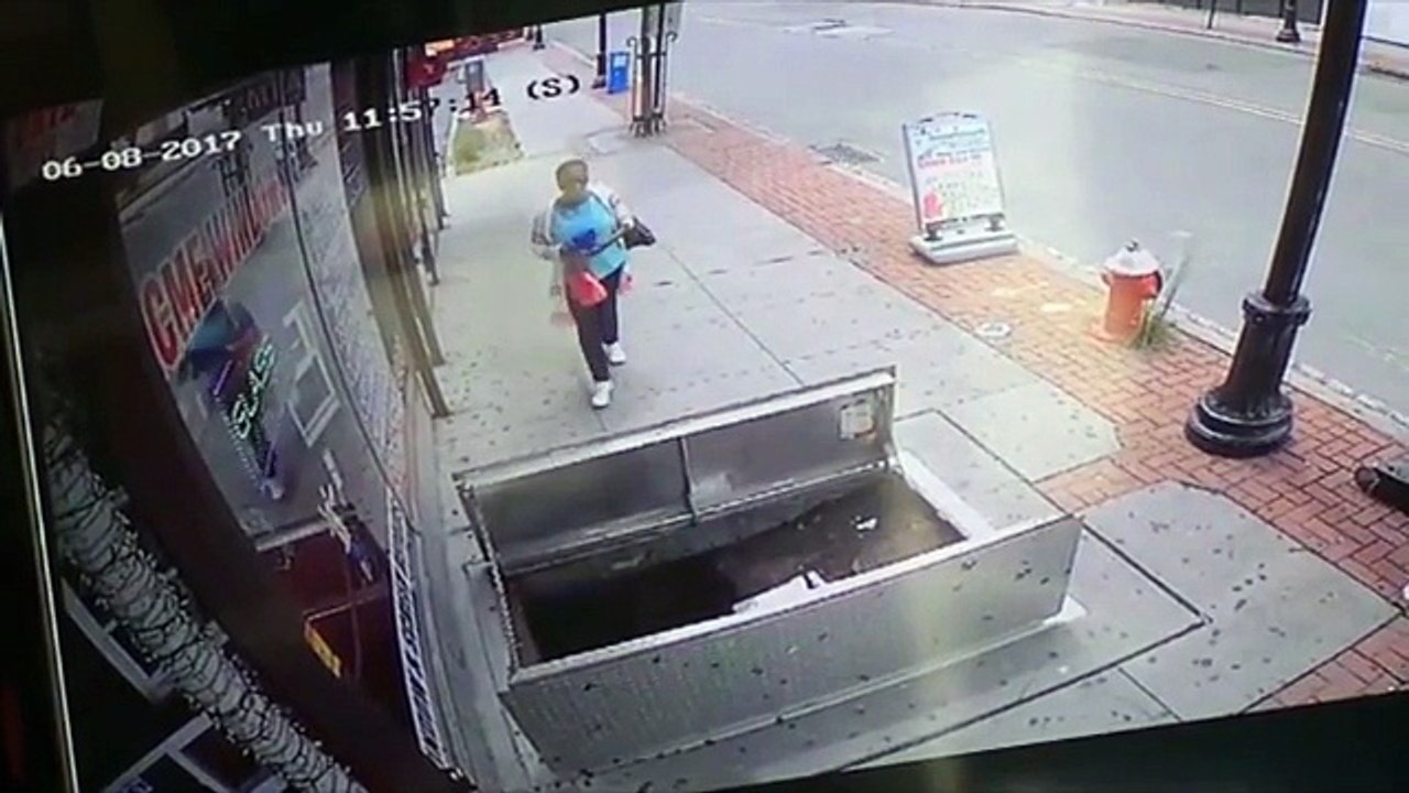 Shocking moment woman, 67, distracted by her phone suffers serious injuries when she plunges through an open sidewalk