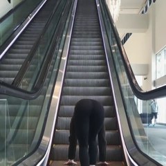 Une femme réussit à monter un escalator sur les mains