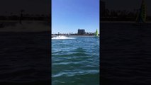 un homme en flyboard aide un skipper en catamaran