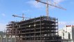 Time-lapse  Wide view of tower cranes with flowing clouds