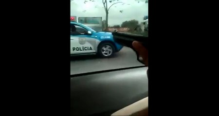 Un gang pointe 2 pistolets vers une voiture de police.