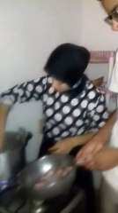 Farah met les morceaux de poulet à cuire sous l’œil d'Hicham