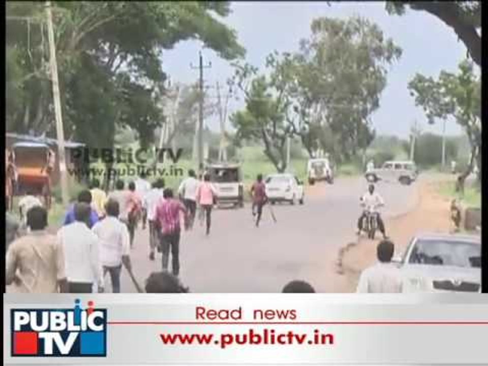 Yamanur people with sticks in hand follow police jeeps to stop them entering the village