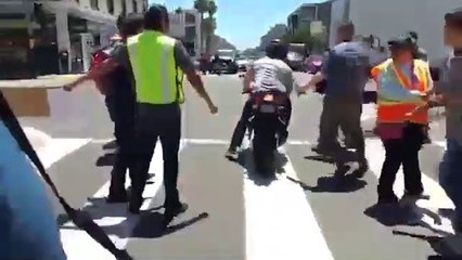 Un motard force un barrage de manifestants anti-Trump allongés au sol