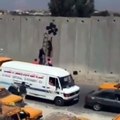 L'artiste Banksy pose son art en Israel sur la West Bank barrier.