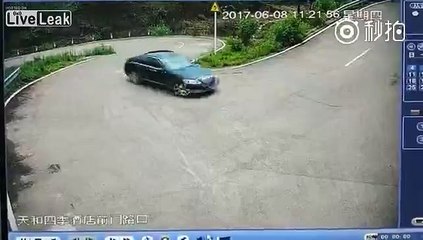 Black car fast reverses down slope to avoid being hit by white one
