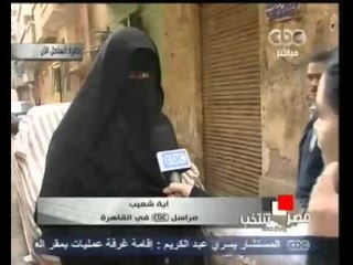 سيدة تحاول استقطاب الناخبين أمام احدى اللجان بالقاهرة