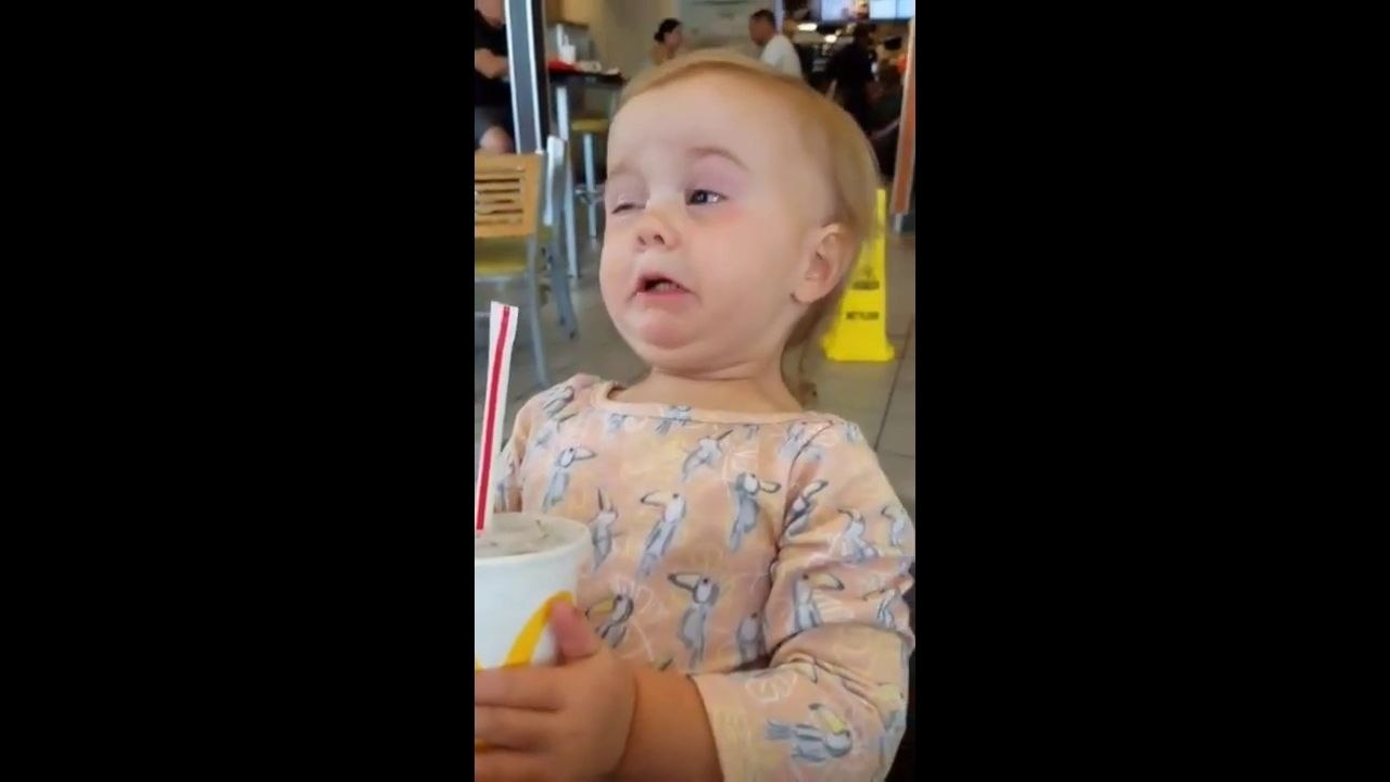 Une enfant goûte du Coca-Cola pour la première fois