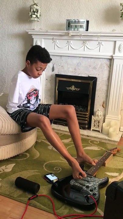 Un enfant sans bras joue "Hold The Line" à la guitare avec ses pieds.