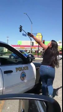 Cette folle attaque une voiture de police à mains nues !