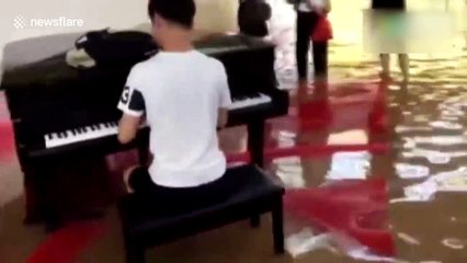 University student plays piano in flooded hall