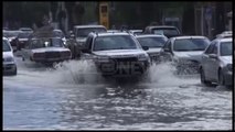 Ora News - Shiu përmbyt rrugët në Vlorë, burri ndihmon të moshuarën të kalojë rrugën
