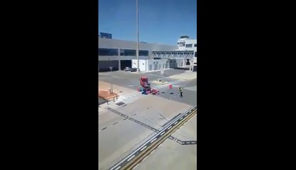 Un bagagiste est en train de jeter des valises.