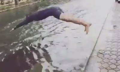 Pria Ini Berenang di Genangan Air Banjir yang Dangkal