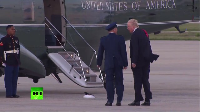 Trump struggles to retrieve marine hat blown off by the wind