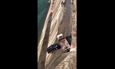 Une dépanneuse dévale une pente et envoie une voiture dans le vide.