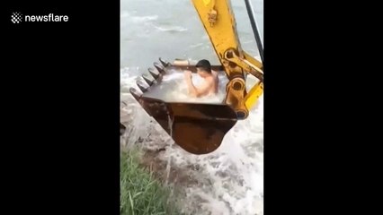 Worker uses digger to shower in river