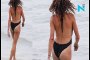Ruffling feathers! Busty Lilly Becker turns heads in plunging black swimsuit as she enjoys beach day in Ibiza without hu