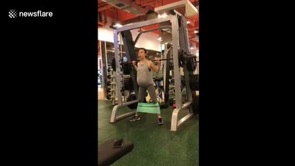 Woman pumps iron while nine months pregnant with twins