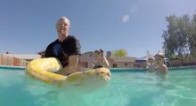 A Burmese Python Is Having A Helluva Good Time Swimming With Its Owners In A Pool