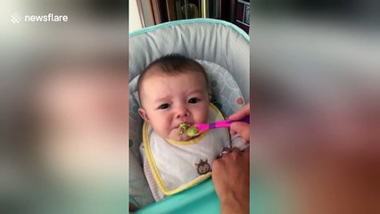 Baby pulls funny faces when trying avocado for the first time