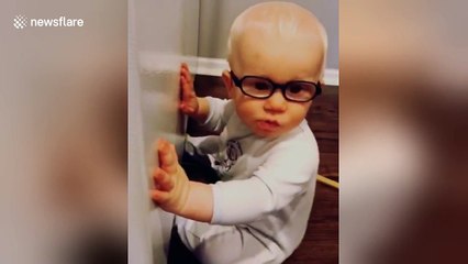 Baby practises his kissing skills on a fridge