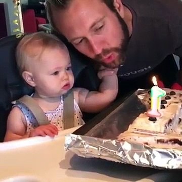 La pauvre ! Ce bébé se brûle la main en voulant éteindre une bougie