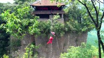 Father and daughter perform kung fu on tight rope over ravine