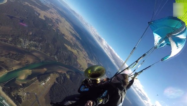 Yer çekimine meydan okuyan paraşütçü gençler atlayış sırasında tuba çaldı