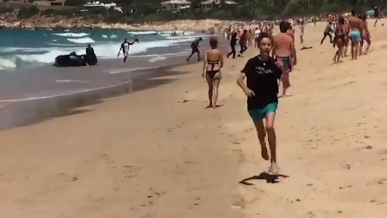 Begegnung am Strand: Flüchtlingsboot trifft auf Touristen