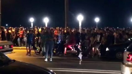 Una multitud persigue a una mujer en vaqueros y camiseta en Marruecos