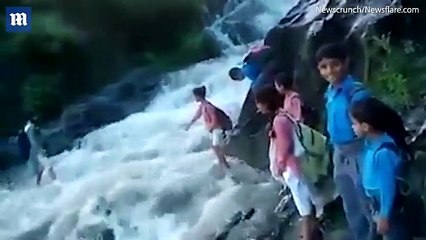 Footage shows children in India crossing a raging river